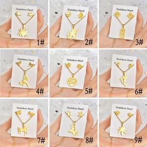 Macro view showing nine gold stainless steel animal pendant necklace and earring sets