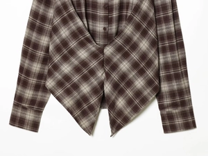 Detail of plaid long sleeve shirt showing unique cross V-cut hem and button details