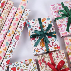 Detail of romantic heart print wrapping paper rolls with ribbon tied gift boxes