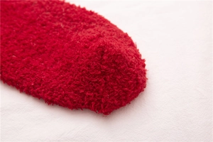 Nahaufnahme der flauschigen roten Korallenfleece-Wintersocken mit weicher Plüschstruktur