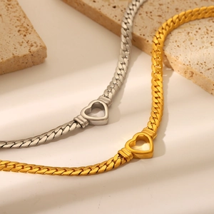 Close-up of punk Cuban chain necklaces in gold and silver with hollow heart charms
