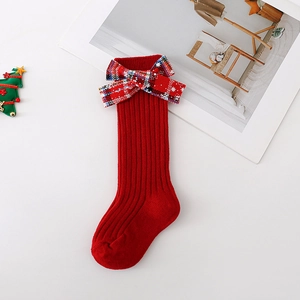 Detail view of red Christmas stockings for kids with a plaid bow on a clean white background