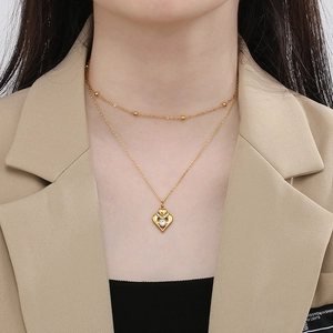 Close-up of double-layer gold heart necklace with zircon pendant on a model