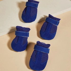 Close-up of blue breathable mesh and suede fabric dog shoes on beige geometric display stand