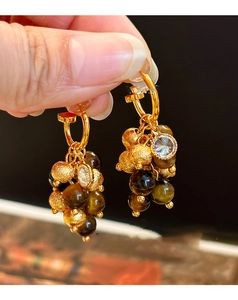 Macro view of vintage tassel earrings with tiger eye stone and crystal beads