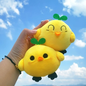 Detailed close-up of yellow plush toy pendants with green sprouts against blue sky