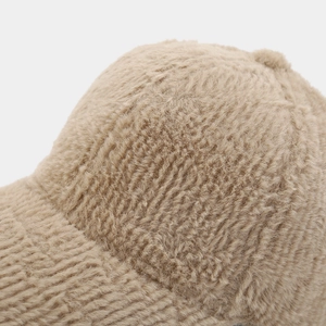 Gros plan sur la texture épaisse en fausse fourrure kaki d'une casquette d'hiver