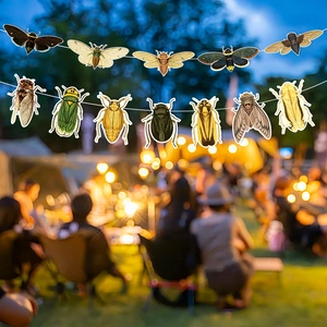 Detail of colorful cicada insect party banners hanging over a warm campfire scene