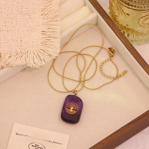 Detailed close-up of a purple crystal Tree of Life pendant in a premium jewelry box