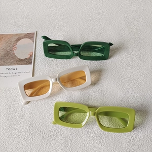 Set of retro square frame sunglasses in deep green, white, and light green on white background