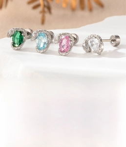 Macro shot of titanium steel snake earrings with colorful oval zircon and screw backs