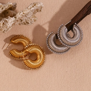 Detailed view of gold and silver textured hoop earrings with sparkling zircon borders