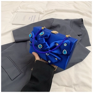 Elegant blue satin evening bag with rhinestone bow detail and gold chain strap