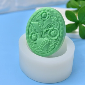 Green rose and butterfly relief soap candle with white silicone mold on blue background