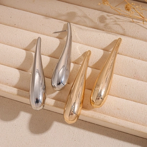 Minimalist high-polish metal teardrop earrings in gold and silver on display