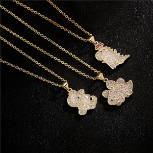 Three gold-plated dinosaur necklaces with cubic zirconia pendants on black leather