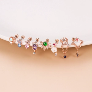 Detail of rose gold stud earrings featuring stars, moon and heart designs with zircons