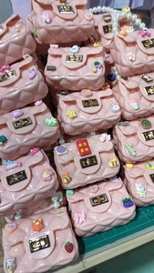 Detail of pink jelly handbags with quilted patterns, pearl handles, and cartoon charms
