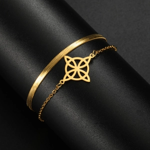 Detail of gold double-layered bracelet with flat snake chain and geometric hollow charm