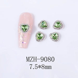 Macro detail of 7.5x8mm heart-shaped nail gems with green crystal and micro zircon rim
