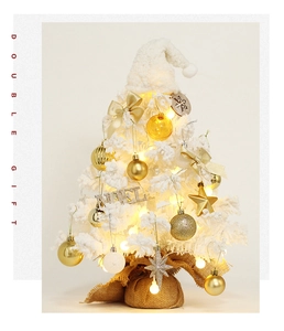 Close-up of a white flocked mini Christmas tree with warm LED lights and ornaments