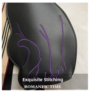 Detail of black leather bag with purple embroidery and striped woven shoulder strap