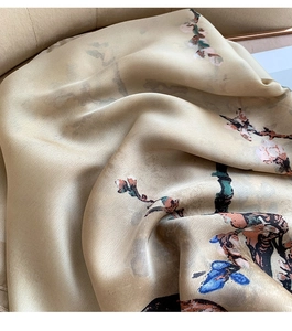 Detail of elegant champagne silk scarf with oriental plum blossom floral print texture