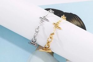 Detailed view of gold and silver heartbeat design bracelets with toggle OT closure