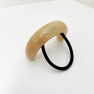 Détail de l'ornement en résine marbrée en U sur l'élastique à cheveux haute élasticité
