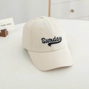 Detailed close-up of Sunday letter embroidery on a beige canvas baseball cap