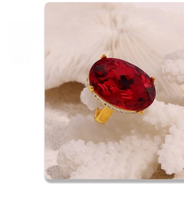 Makroaufnahme eines ovalen roten Edelsteinrings mit Pavé-Diamanten auf Koralle