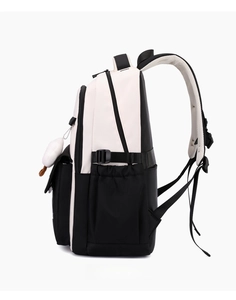 Side view of a high-capacity black and white nylon backpack with a white plush pompom charm