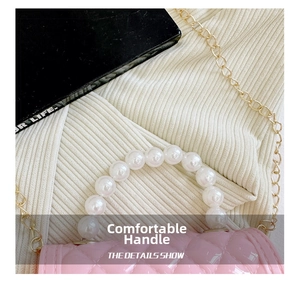 Detail view of pink mini jelly bag with pearl handle and golden chain strap