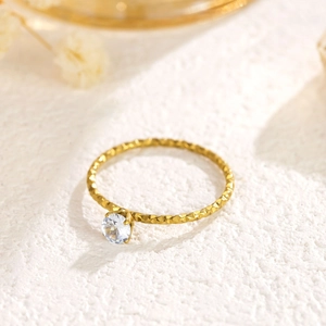 Minimalist 18k gold ring with round brilliant cut diamond and faceted textured band