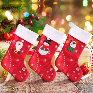 Three felt Christmas stockings with Santa, snowman and deer characters on a wooden table