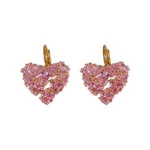 Élégantes boucles d'oreilles dorées avec cœurs en zircon rose sur fond blanc pur