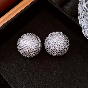 Macro shot of silver sphere earrings with micro-pave cubic zirconia on black tray