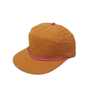 Détail de la casquette 5 pans orange avec cordelette magenta et bord plat surpiqué