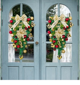 Detail of Christmas teardrop swag with red and gold baubles on a blue arched door