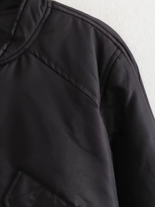 Close-up of shoulder stitching and smooth fabric texture on black bomber jacket