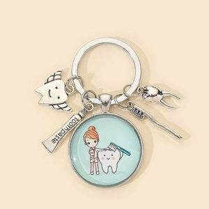 Detail of dentist keychain with silver charms of tooth, toothpaste and toothbrush