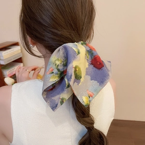 Detail of elegant floral print bow hair clip with oil painting texture on hair tie