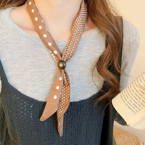 Close-up of brown polka dot silk scarf necklace with a round wood ring clasp detail