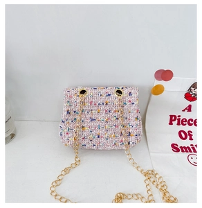 Detailed view of pink tweed mini bag featuring gold chain strap and colorful woven fabric