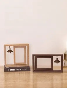 Close-up of double-sided rotating wooden photo frame with decorative mini pendant lamp