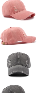 Detailed view of distressed denim baseball cap with metal buckle and ripped texture