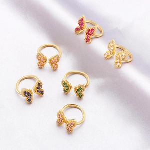 Detailed view of colorful butterfly open rings with assorted gemstones on silk fabric