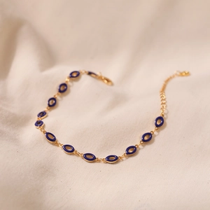 Detailed view of vintage gold chain bracelet with blue enamel oval charms and lobster clasp
