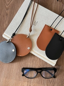 Detail of faux leather magnetic glasses clip pendants in black, brown and grey colors