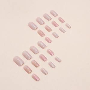 Sparkling nude pink squoval press-on nails with fine glitter finish in S-curve layout